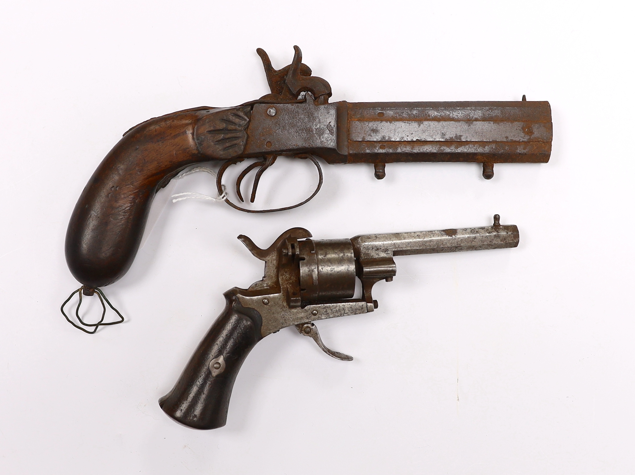 A 19th century six shot pinfire revolver with folding trigger, barrel 8cm, together with a relic over and under double barrelled percussion pistol, barrel 10cm (2)